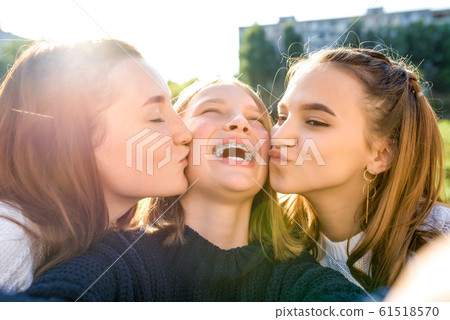 3 girls schoolgirls teenagers 13-15 years old, in autumn day, in summer in city, take pictures of selfie on smartphone, social Internet. Having fun, relaxing, laughing and rejoicing. Braces on teeth. 3 girls schoolgirls teenagers 13-15 years old, in autumn day, in summer in city, take pictures of selfie on smartphone, social Internet. Having fun, relaxing, laughing and rejoicing. Braces on teeth. 61518570