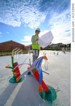 Professional engineer architect worker with protective helmet and blueprints paper at house building Professional engineer architect worker with protective helmet and blueprints paper at house building 61518949