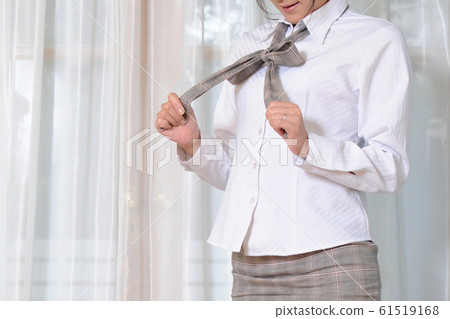 Woman unwinding blouse ribbon 02 61519168