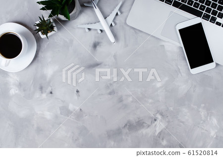 Travel booking concept. Laptop, passports, smartphone and airplane model on gray concrete.  61520814