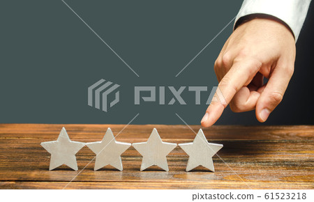 Critic puts the fourth star. The concept of the rating of hotels and restaurants. The evaluation of visitors. Quality level, good service. Customer rating. Feedback. Four stars 61523218
