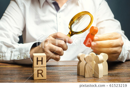 Wooden blocks with the word HR and businessman with a crowd of workers. Hiring, hire concept. Creation of a business team. Recruiting. Headhunting services. Working staff. Headhunter 61523219