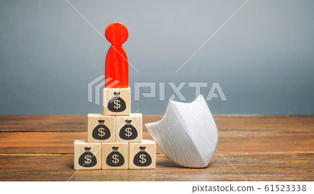 Wooden blocks with money, man and protection shield. Concept security of money, guaranteed deposits. Client rights protection. Compensation for losses in inflation, safeguarded investment capital. 61523338
