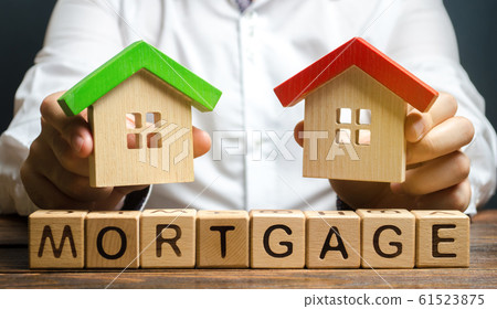 Wooden blocks with the word Mortgage and businessman. The concept of buying a home on credit. Loan for apartments and housing. Interest rates. Creditor, debtor. Real estate Wooden blocks with the word Mortgage and businessman. The concept of buying a home on credit. Loan for apartments and housing. Interest rates. Creditor, debtor. Real estate 61523875