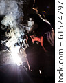 worker welds metal structures by electric arc 61524797