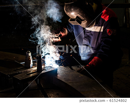 worker welds metal structures by electric arc worker welds metal structures by electric arc 61524802