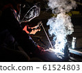 worker welds metal structures by electric arc 61524803