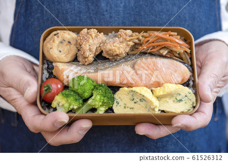 拿著午餐盒的男人的手的特寫鏡頭 拿著午餐盒的男人的手的特寫鏡頭 61526312