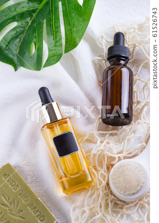 Cosmetic bottle with serum and hyaluronic acid , palm leaf, olive soap and Reusable shopping bags on a white towel 61526743