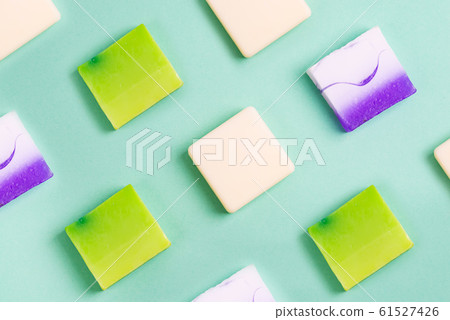 Handmade organic rows of various colorful homemade bar soaps on green 61527426