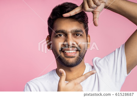 Portrait of handsome Indian guy standing on pink Portrait of handsome Indian guy standing on pink 61528687