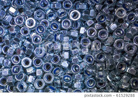 A pile of galvanized industrial nuts. Metal nut texture, industrial background. A pile of galvanized industrial nuts. Metal nut texture, industrial background. 61529288
