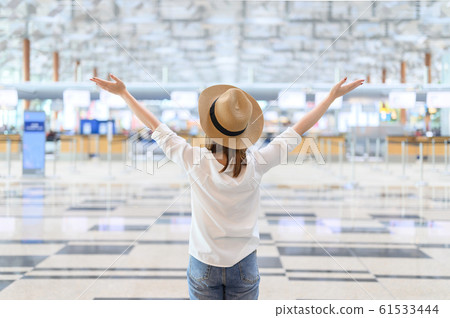 A woman with happiness raising hands on in airport 61533444