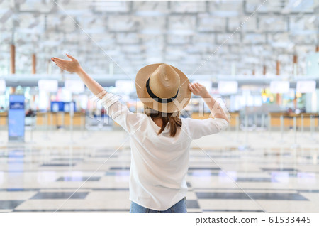 A woman with happiness raising hands on in airport A woman with happiness raising hands on in airport 61533445