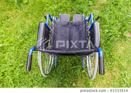 Empty wheelchair standing on grass in hospital 61533814