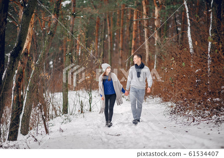 Cute and loving couple in a winter forest Cute and loving couple in a winter forest 61534407