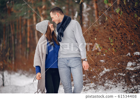 Cute and loving couple in a winter forest Cute and loving couple in a winter forest 61534408