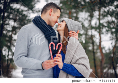 Cute and loving couple in a winter forest 61534414