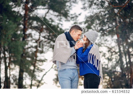 Cute and loving couple in a winter forest 61534832