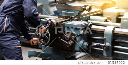 Factory Asian male worker. Asian man Lathe worker in production plant drilling at machine on the factory. Yellow hard hat safety first at mechanic factory. 61537022