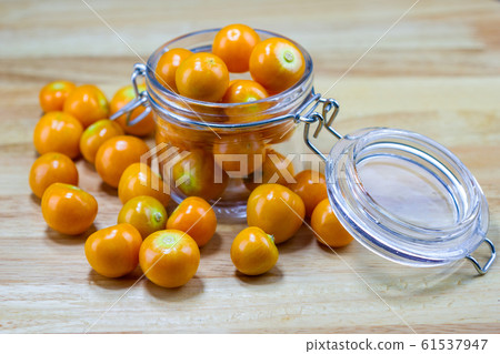 Cape Gooseberry in glass cup on wood table Cape Gooseberry in glass cup on wood table 61537947