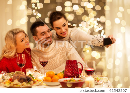 friends taking selfie at christmas dinner 61542207