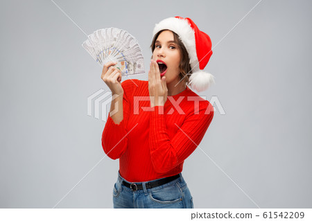 surprised woman in santa hat with money surprised woman in santa hat with money 61542209