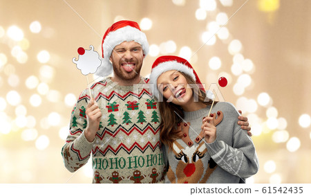 couple with christmas party props in ugly sweaters 61542435