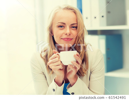 happy businesswoman drinking coffee at office happy businesswoman drinking coffee at office 61542491