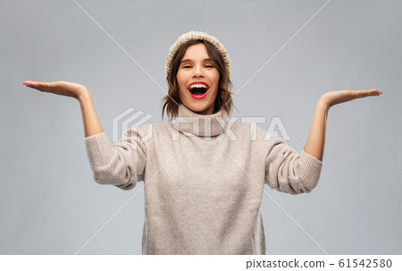 young woman in winter hat holding something young woman in winter hat holding something 61542580