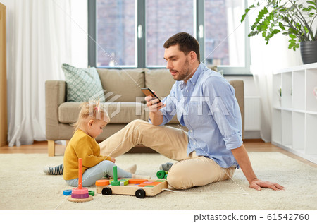 father with smartphone and baby daughter at home father with smartphone and baby daughter at home 61542760