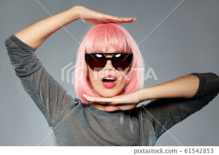 happy woman in pink wig and black sunglasses 61542853