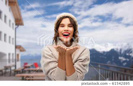 woman in winter hat sending air kiss at ski resort woman in winter hat sending air kiss at ski resort 61542895