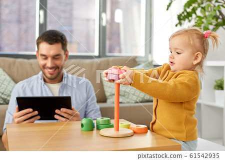 father with tablet pc and baby daughter at home father with tablet pc and baby daughter at home 61542935