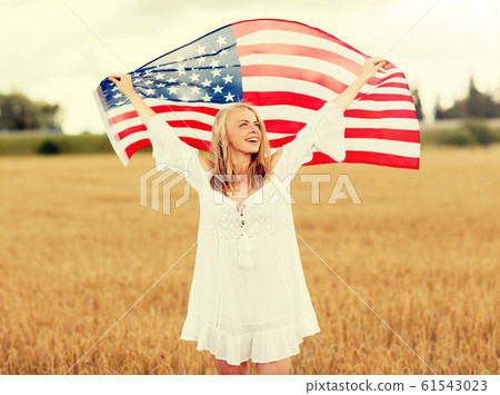 happy woman with american flag on cereal field 61543023