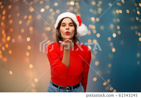 woman in santa hat sending air kiss on christmas woman in santa hat sending air kiss on christmas 61543245