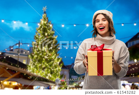 woman in hat holding gift box at christmas market woman in hat holding gift box at christmas market 61543282