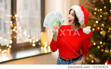 happy woman in santa hat with money on christmas 61543418