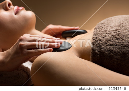 close up of woman having hot stone massage at spa close up of woman having hot stone massage at spa 61543546