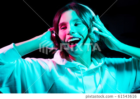 woman in headphones listening to music and dancing woman in headphones listening to music and dancing 61543616