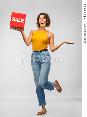 happy smiling young woman posing with sale sign happy smiling young woman posing with sale sign 61543633