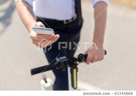 businessman with smartphone and electric scooter businessman with smartphone and electric scooter 61543668