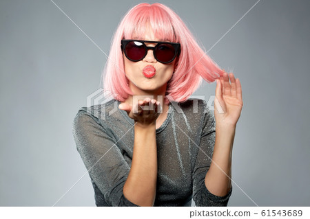 woman in pink wig and sunglasses sending air kiss 61543689