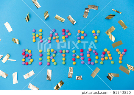 happy birthday of candies and confetti on blue 61543830
