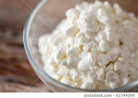 close up of cottage cheese in bowl on wooden table 61544099