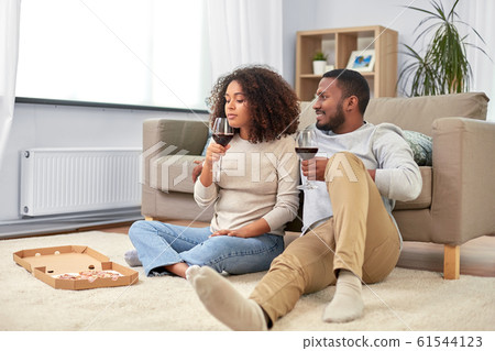 happy couple with wine and takeaway pizza at home happy couple with wine and takeaway pizza at home 61544123