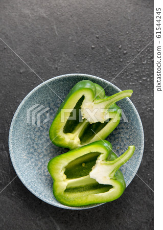 cut green pepper in bowl on slate stone background cut green pepper in bowl on slate stone background 61544245