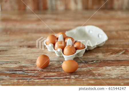 close up of eggs in cardboard box on wooden table close up of eggs in cardboard box on wooden table 61544247