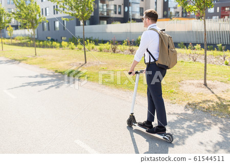 businessman with backpack riding electric scooter 61544511