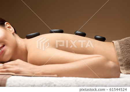 smiling woman having hot stone massage at spa smiling woman having hot stone massage at spa 61544524